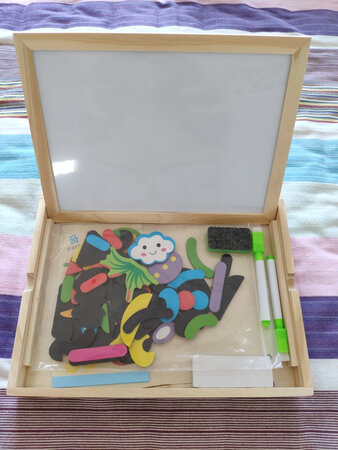 为了满减凑单买的玩具，收到感觉很惊喜。里面有一块双面画板，一面黑板，一面白板。家里其实有一面黑板墙，本来想着要不要再买块白板给娃玩，现在不用了，这块迷你小白板能用上一段时间了。拼图零件做工也不错，但是因为娃还没过口欲期，暂时还不敢给她玩。