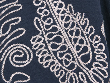 运用了顺色的单色绣花,以绣针引素线,采用锁链绣的方式,线迹