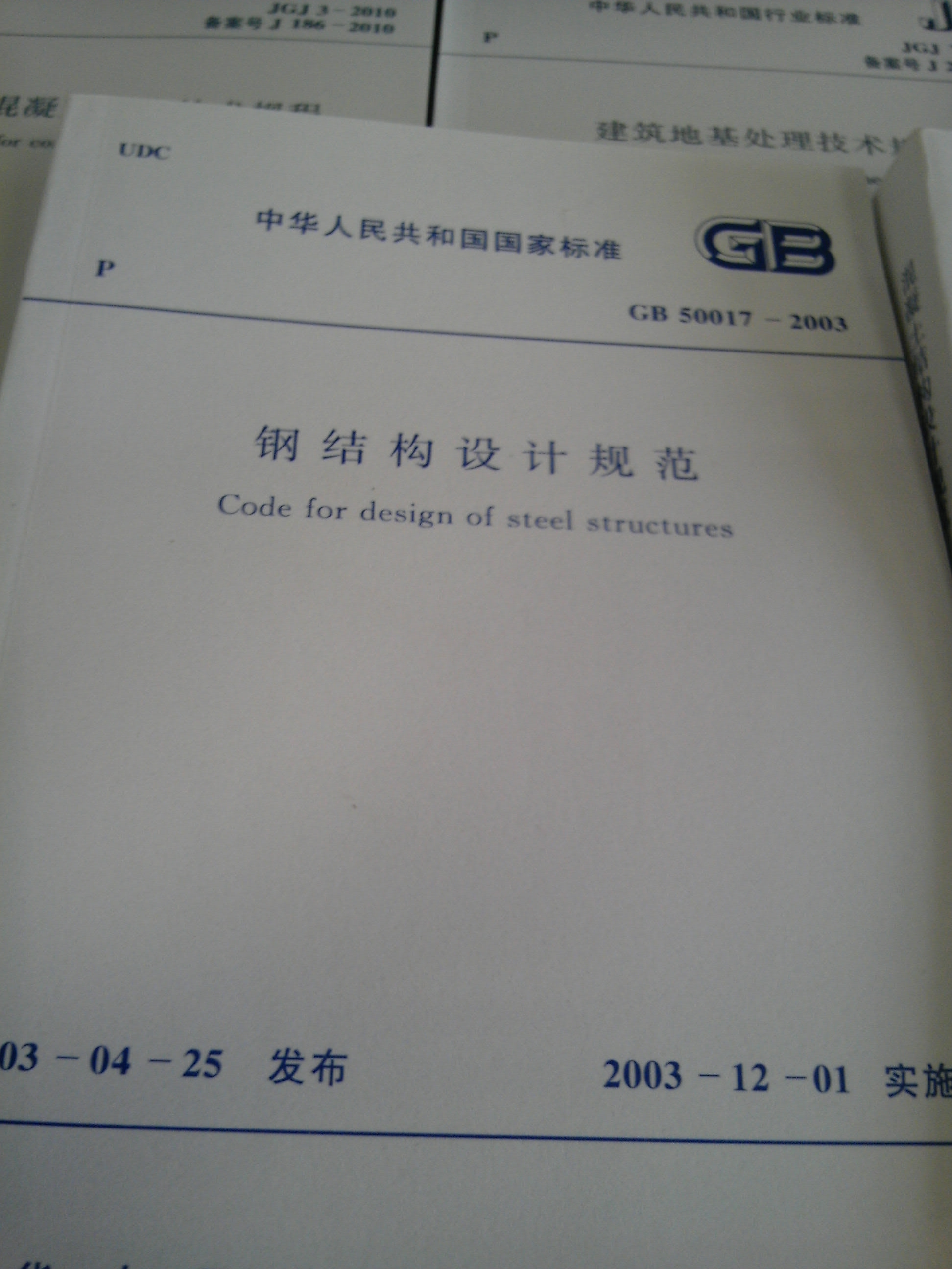 由北京钢铁设计研究总院会同有关设计、教学和科研单位组成修订编制小组，对《钢结构设计规范》GB17-88进行全面修订由建设部以公告第147号文颁布，自2003年12月1日实施。本规范共11章和6个附录。其主要内容包括总则、术语和符号、基本设计规定、受弯构件的计算、轴心受力构件和拉弯、压弯构件的计算、疲劳计算、连接计算、构造要求、塑性设计、钢管结构、钢与混凝土组合梁。本次修订在对原规范条文进行修改、调整和删除的同时，新增了许多内容，如荷载和荷载效应计算，单轴对称截面轴压构件考虑绕对称轴弯扭屈曲的计算方法、带有摇摆柱的无支撑纯框架柱和弱支撑框架柱的计算长度确定方法、梁与柱的刚性连接，连接节点处板件的计算、插入式柱脚、埋入式柱脚及外包式柱脚的设计和构造规定，大跨度屋盖结构的设计和构造要求的规定、提高寒冷地区结构抗脆断能力的要求的规定、空间圆管节点强度计算公式等。