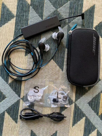 BOSE QC20入耳式耳机，在传统听音的耳机设计方面并没有什么特别。官方强调的技术包括TriPort声学结构设计，对应带来是更充沛的低频。另外在佩戴舒适性和稳定性上，BOSE的鲨鱼鳍大家应该不会陌生。类似的技术被称之为“耳翼”设计，近年来在越来越多入耳式耳机上出现[包括运动款]。鲨鱼鳍StayHear+®，它的作用并不是挂住你的耳朵，而是用柔软的橡胶顶住外耳内圈的凹陷，让佩戴更为稳定。不得不说，近年来有不少耳机开始使用类似的设计，但橡胶材质和触感对于这种需要受力固定的结构设计非常重要，QC20与IE2的佩戴舒适度还是要好于我们曾经尝试过的一些耳机。你要相信入耳式耳机的橡胶塞的橡胶一定有不合格的，因为我曾经就遇到某耳机一戴上耳朵皮肤过敏的情况。
耳机连接了一个很薄的小盒子，小盒子引线伸出10cm长度就是3.5mm接口与手机或其他音源相连，包括耳塞等在内，QC20整体重量为44克左右，而这个小盒子的重量大概在24克左右[实测]。可以方便的和手机一起装在口袋里，并不显得累赘。耳机线长1.2m左右。这个小盒子内部是电池与主动降噪相关信号处理电路。耳机降噪做的很棒，舒适度很好，游戏性能也很高！