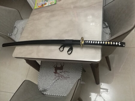 已经到货两个多月了才来评价，一直摆在酒柜上，很美。整刀几乎没有什么瑕疵，刀身平直，有一层厚厚的防锈油，擦掉了用赠送的油又重新涂抹了一遍，感觉赠送的油没有出厂时带的油厚腻，但应该也能起到防锈的作用。这把刀拿在手上还是比较有份量的，做工不错，近期还打算入手一把短款。