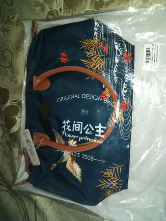 外观颜值：高贵典雅漂亮
材质手感：质感好顺滑
容量空间：大，即使是出门旅行也很实用
做工细节：细致精美
适用场合：广泛
其他特色：性价比很高
一直想买一个有容的包，看到这款就被吸引到了。因为买过这个牌子的其他款包，感觉它所用的材料比较好，靠谱，而这款包我觉得最美的是它的刺绣构图，它的刺绣十分精美，水草配上飞鹤，色彩搭配既美观又雅致，做工也很认真细致。拿到手上了，有点意外的是这么大容量的包外观上并没有给人一种大得离谱像是挎着个大口袋的感觉。很满意的一次购物。