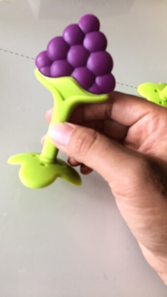 MDB婴儿牙胶硅胶磨牙棒玩具宝宝安抚咬咬胶上面的草莓和下面的托手是一体的吗，孩子咬扯的时候会不会脱开？